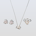 Pearl jewelry set with necklace, earrings, and ring on a light gray background