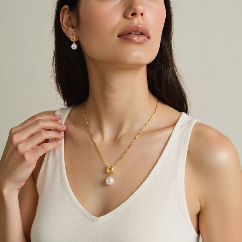 Woman wearing a gold necklace with a pink pendant against a neutral background