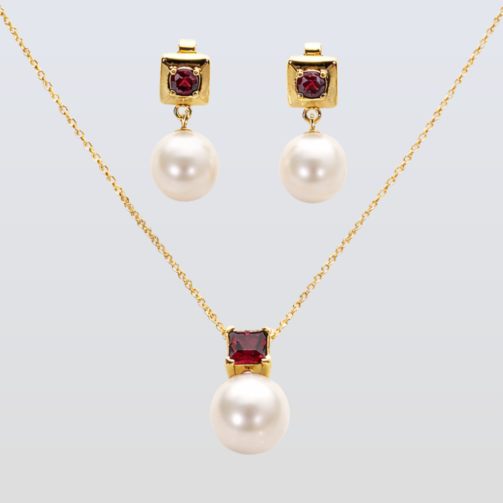 Pearl necklace and earrings with red gemstones on a light gray background
