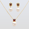 Pearl necklace and earrings with red gemstones on a light gray background