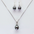 Pearl necklace and earrings set on a light gray background