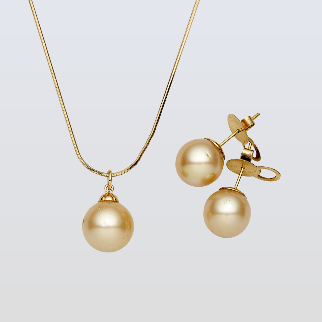 Gold necklace and earrings on a light gray background