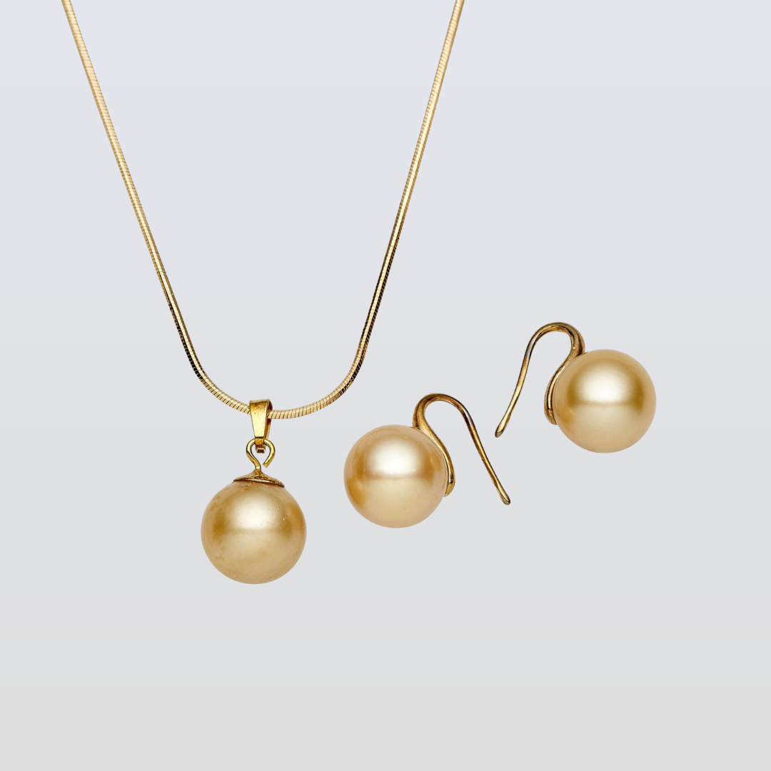 Gold necklace and earrings on a light gray background