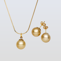 Gold necklace and earrings on a light gray background