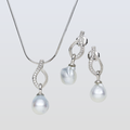 Pearl necklace and earrings set on a light gray background