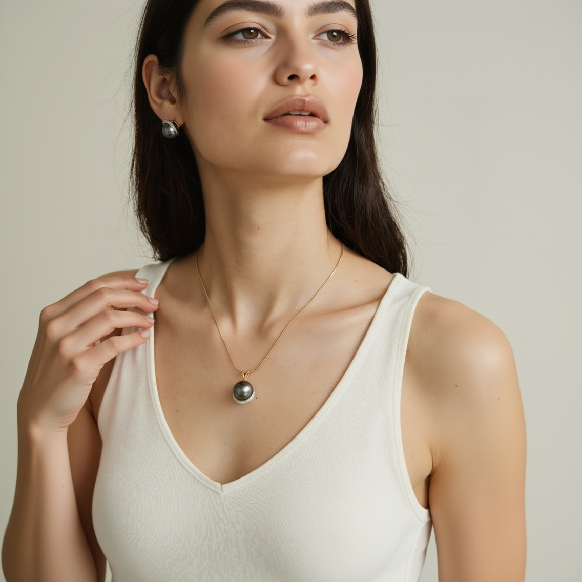 Woman wearing a necklace with a black pendant on a neutral background
