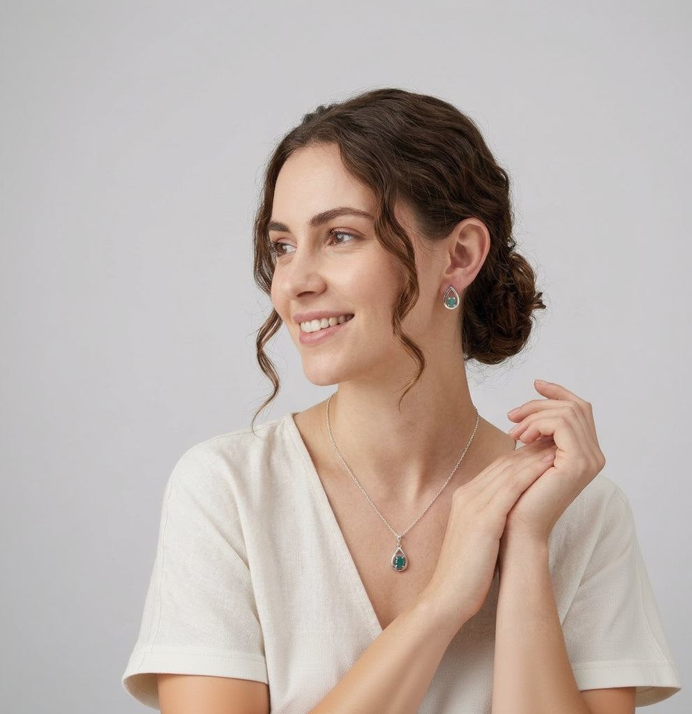Woman wearing a necklace and earrings with a plain background