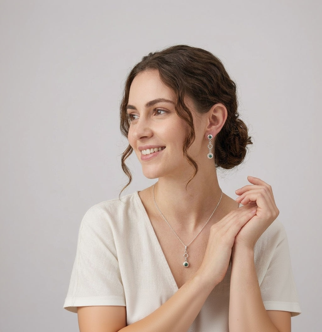 Woman wearing a necklace and earrings on a plain background