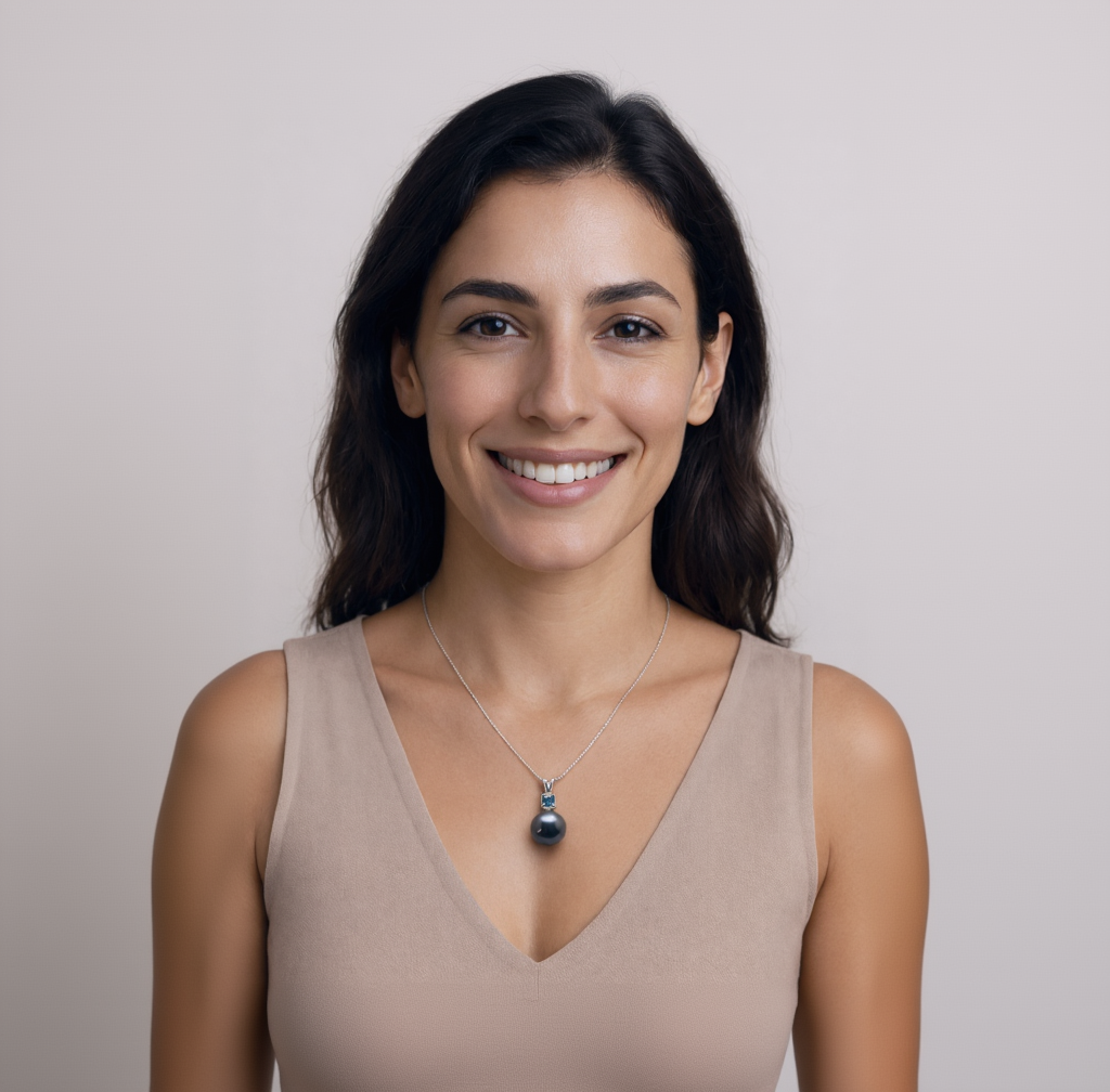 Woman wearing a necklace with a pendant against a plain background